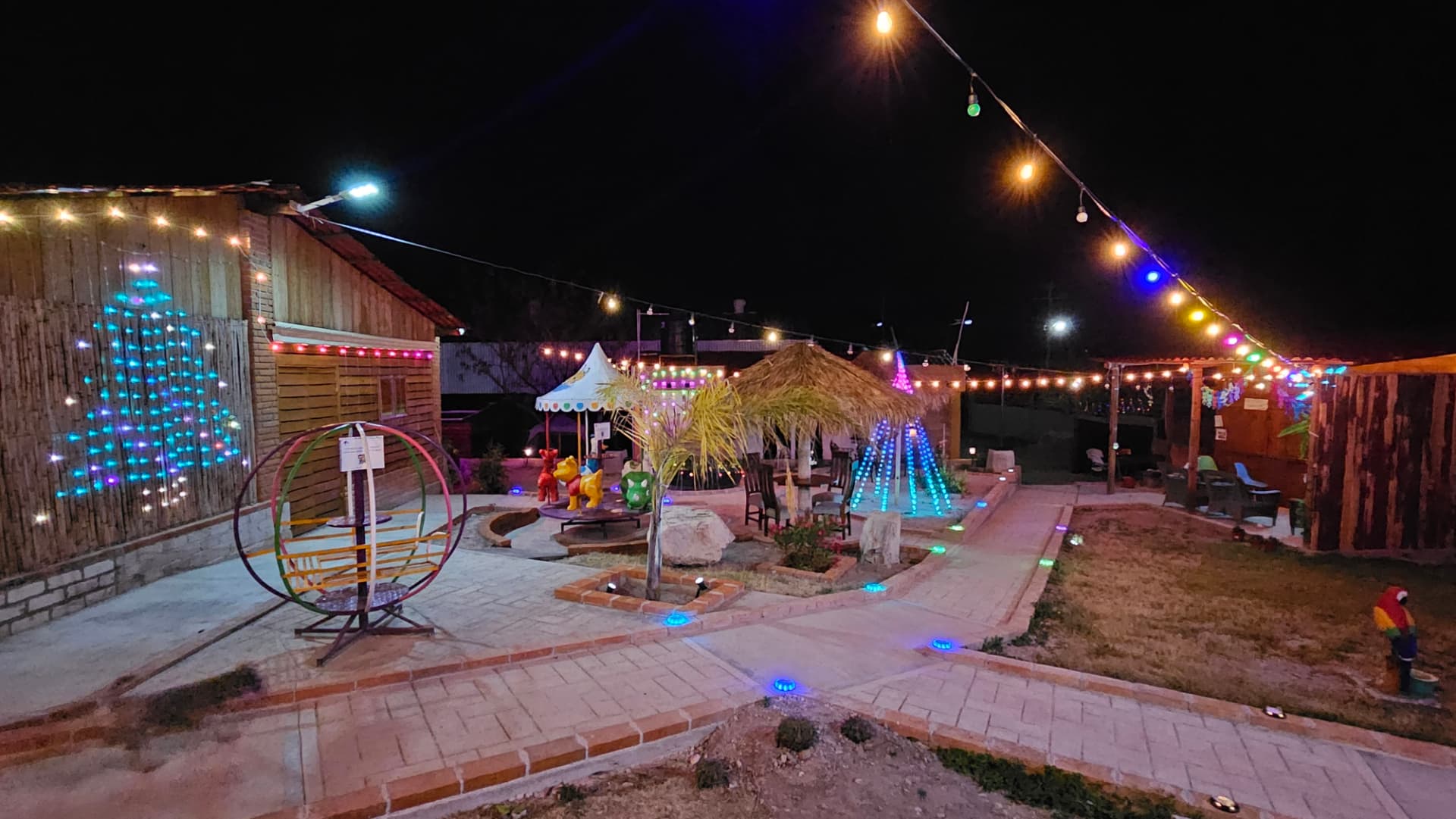 Senderos, palapas y juegos iluminados en el jardín