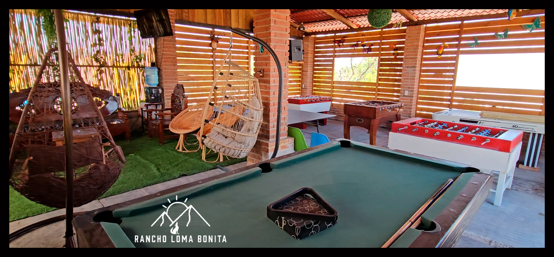 Salón techado con billar, futbolitos, ping pong y sillas colgantes