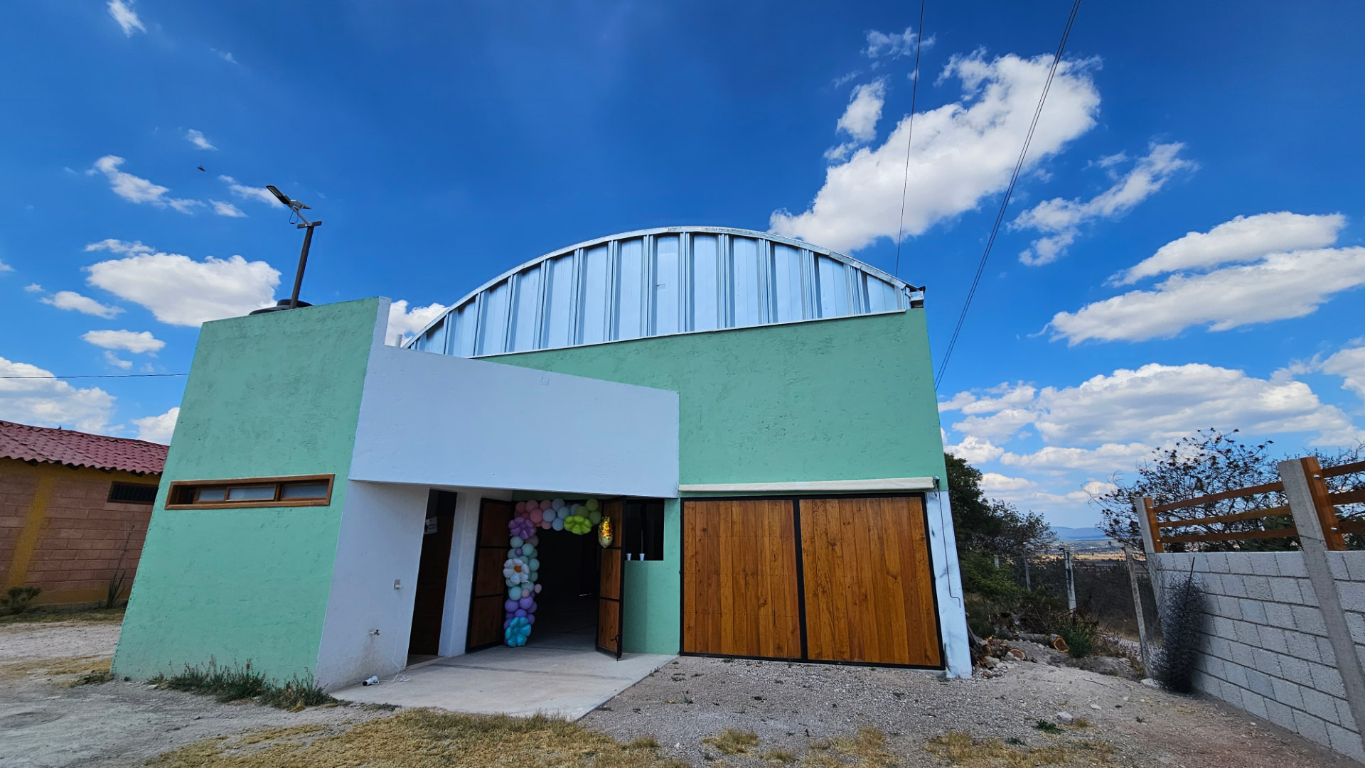 Fachada del salón del Rancho Loma Bonita bajo un cielo azul