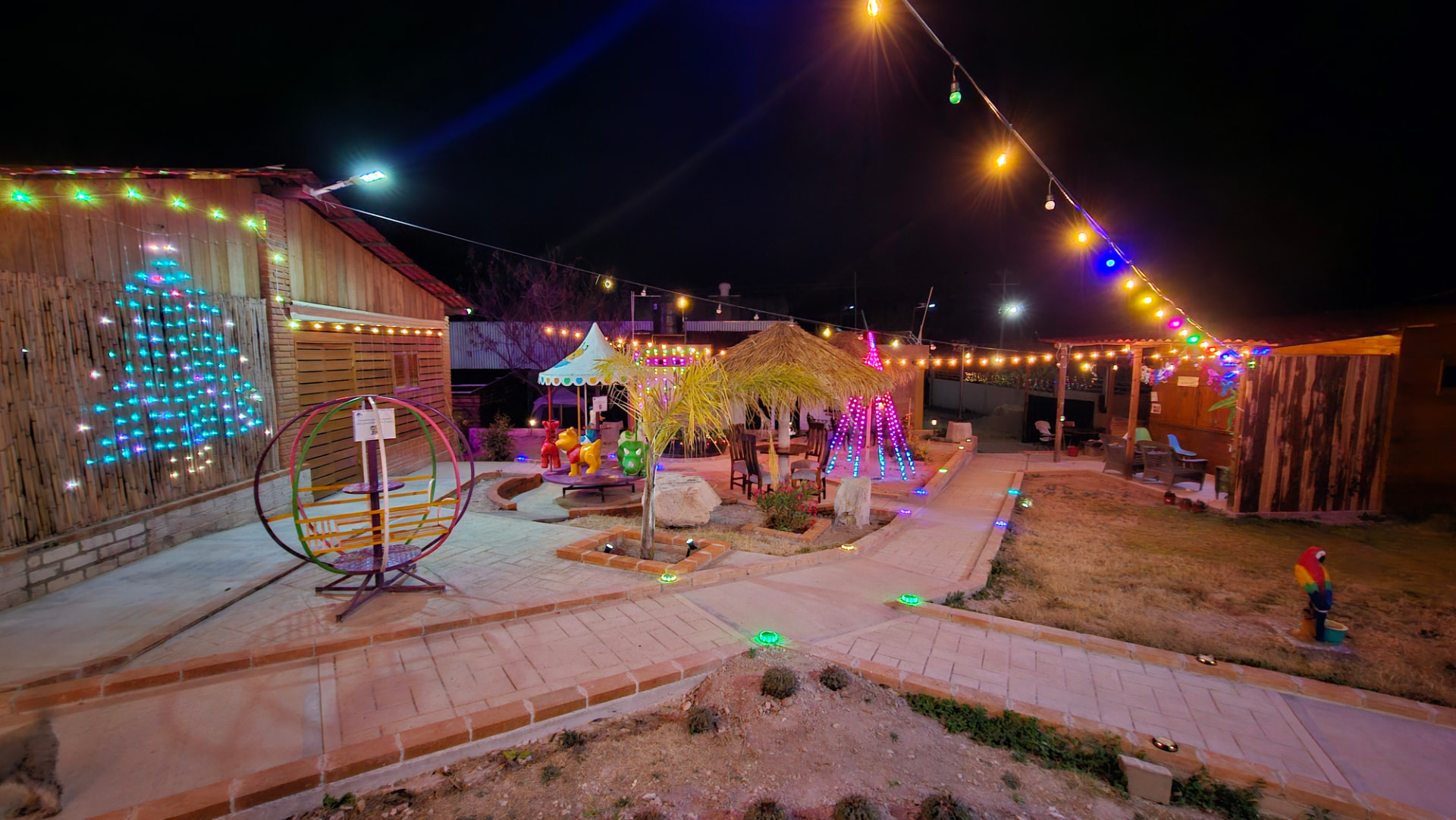 Jardín del rancho iluminado con luces de colores por la noche