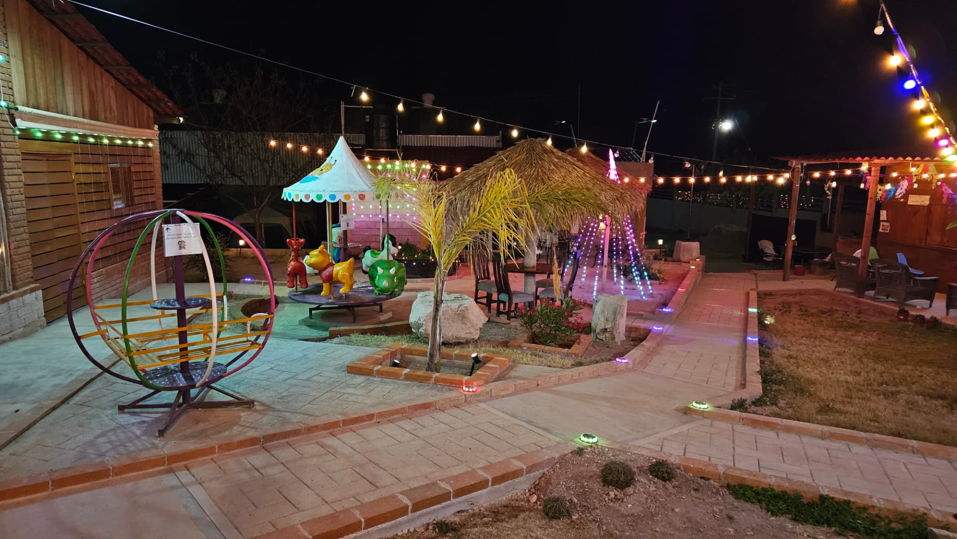 Palapa y área de juegos con iluminación nocturna